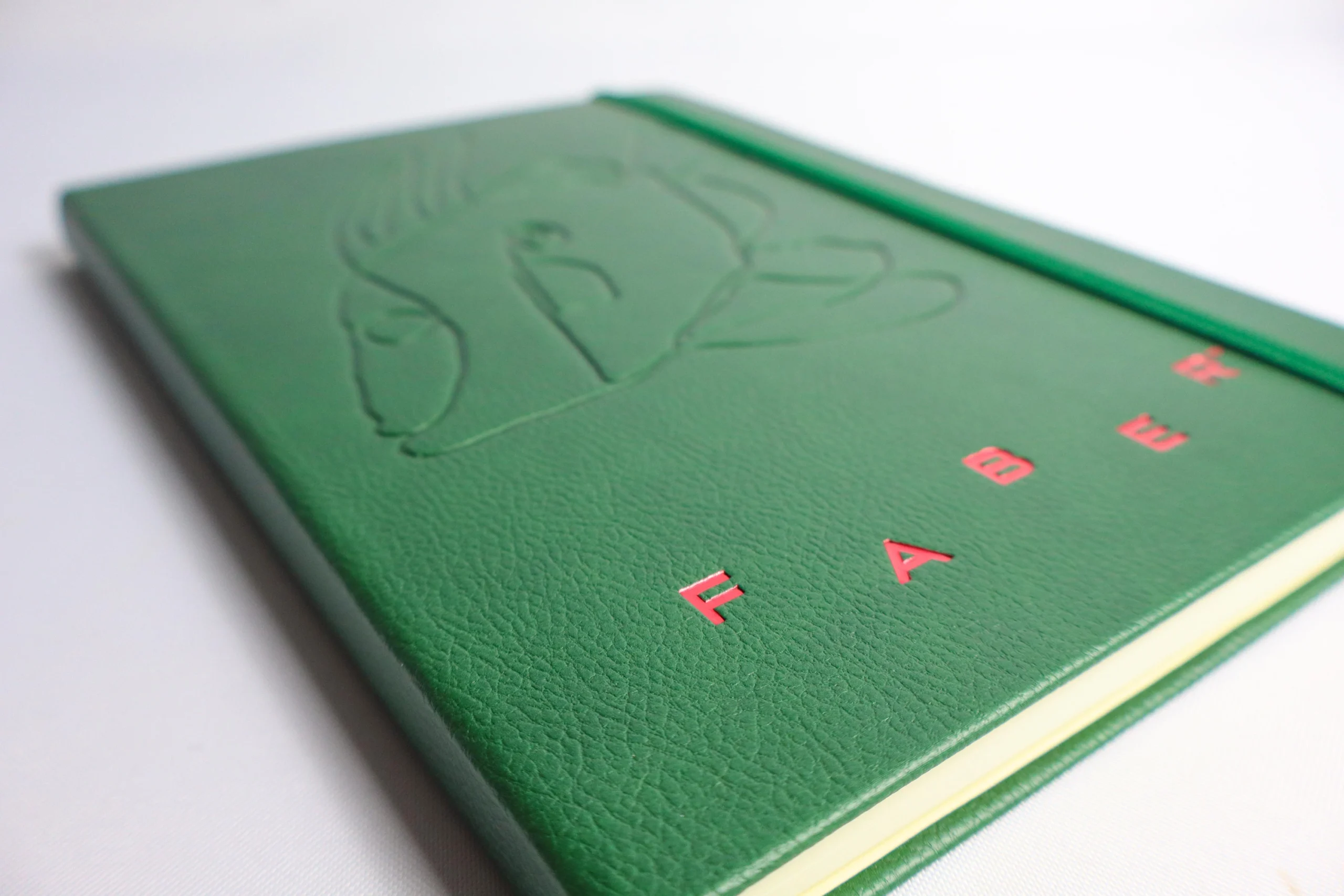 Custom printed notebook for faber featuring debossing and red foil print.