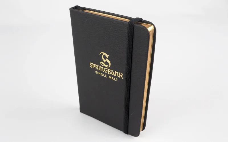 Black leather notebook with gold lettering, 